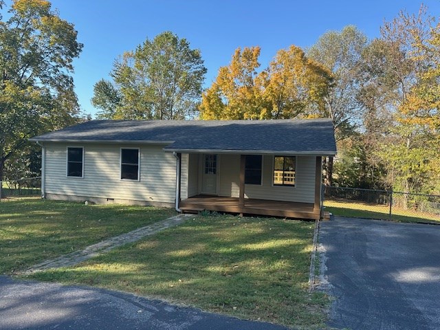 view of front facade featuring crawl space, fence, and a front lawn