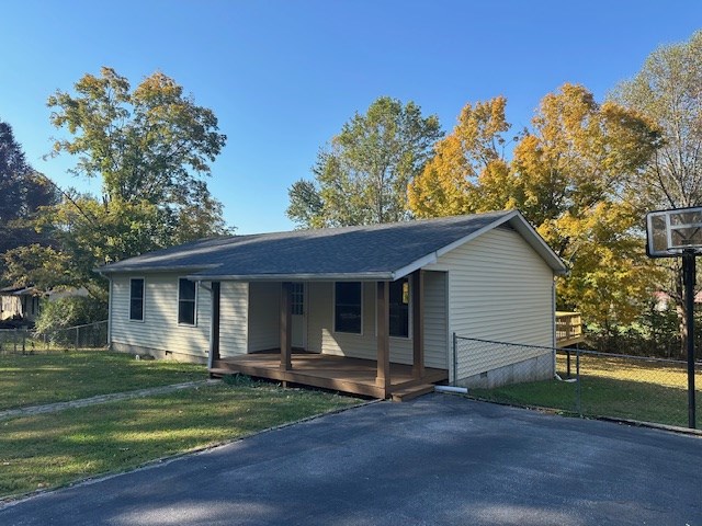 view of front facade with a front lawn, crawl space, and fence