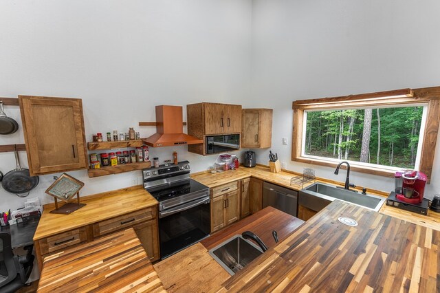 294 Big Piney Loop, Wilder, TN 38589 - kitchen featuring butcher block countertops, stainless steel appliances, island range hood, a sink, and a towering ceiling