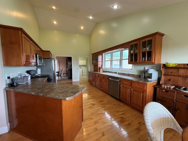 1032 Kendall Smith Rd, Pikeville, TN 37367 - kitchen featuring stainless steel appliances, independent washer and dryer, high vaulted ceiling, brown cabinets, and glass insert cabinets
