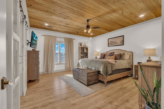 bedroom featuring wood ceiling, crown molding, light wood finished floors, and a barn door