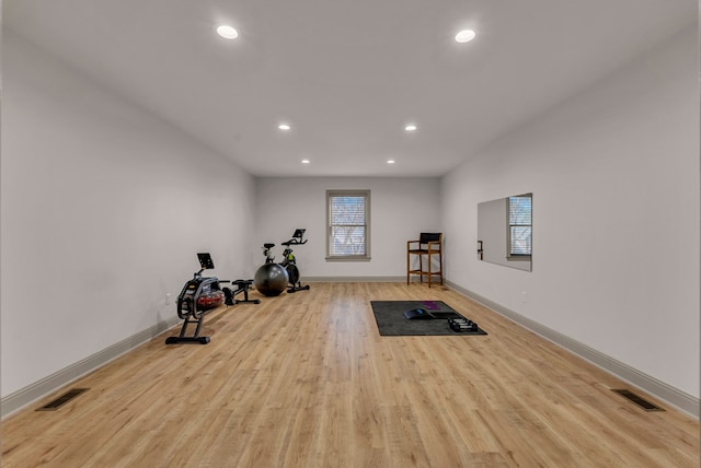 workout room featuring baseboards, recessed lighting, visible vents, and light wood-style floors