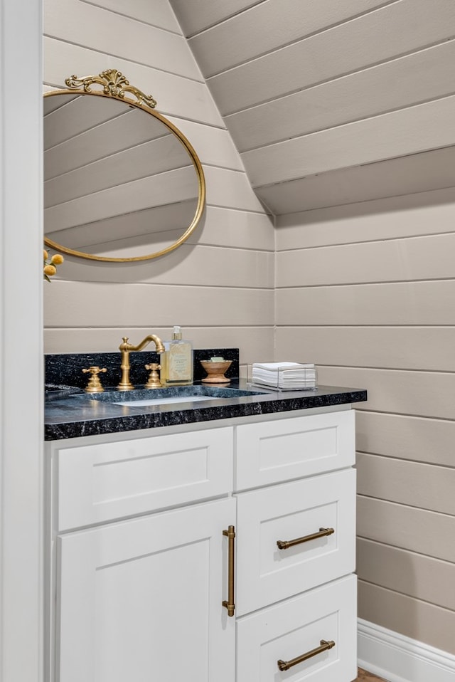 bathroom with vaulted ceiling, wood ceiling, wood walls, and vanity