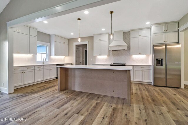 320 Ridge Ln, Monterey, TN 38574 - kitchen with stainless steel appliances, custom exhaust hood, light wood-type flooring, backsplash, and recessed lighting