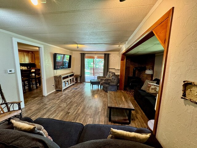 151 Dykes Ln, Crossville, TN 38571 - living room featuring crown molding, wood finished floors, a wood stove, and a textured wall