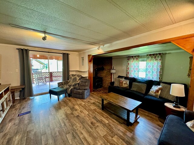 151 Dykes Ln, Crossville, TN 38571 - living area with a wood stove, ornamental molding, wood finished floors, and a textured ceiling