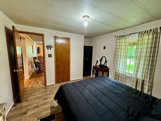 151 Dykes Ln, Crossville, TN 38571 - bedroom with wood finished floors, crown molding, a textured ceiling, and a closet