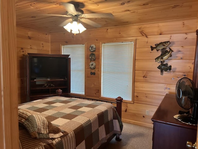 bedroom featuring carpet floors, wooden walls, wood ceiling, and a ceiling fan