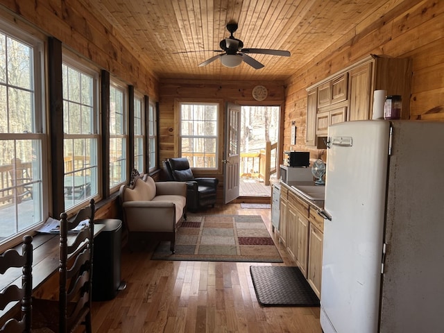 kitchen featuring dark countertops, hardwood / wood-style floors, fridge, wooden ceiling, and wood walls