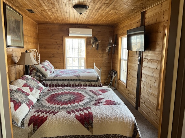 carpeted bedroom featuring an AC wall unit, wooden walls, wood ceiling, and visible vents