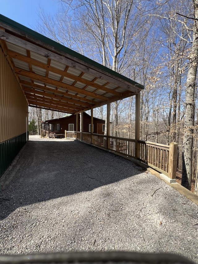 view of parking / parking lot with a carport and gravel driveway