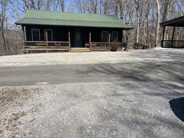 rustic home featuring a porch and metal roof