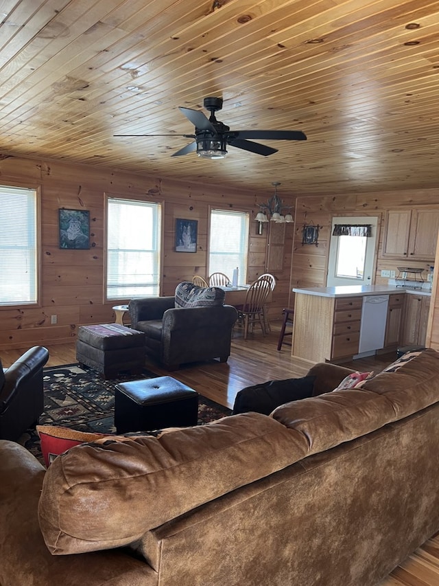 living area featuring ceiling fan, wooden walls, wood ceiling, and wood finished floors