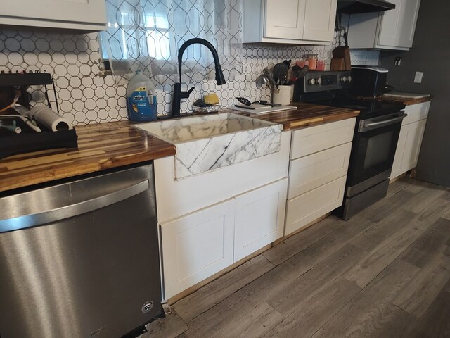 kitchen with appliances with stainless steel finishes, dark wood finished floors, white cabinets, and wooden counters