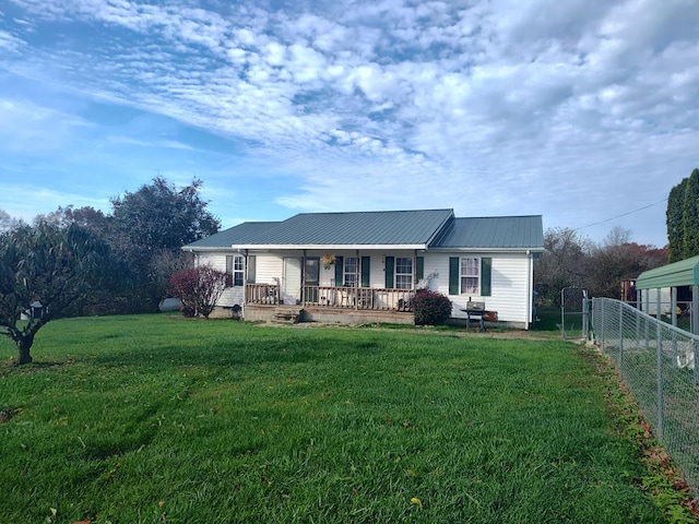 back of house featuring metal roof, a porch, a lawn, and fence