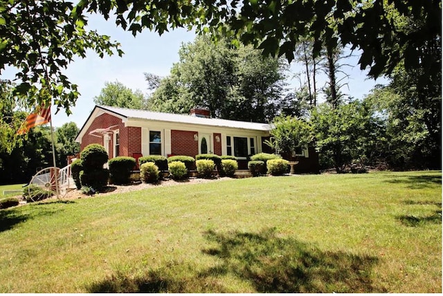 view of front of home with brick siding and a front yard