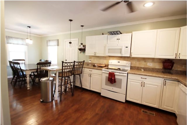 kitchen featuring white appliances, dark wood-style flooring, crown molding, white cabinetry, and pendant lighting