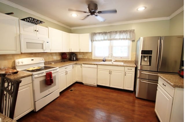 kitchen with crown molding, white appliances, white cabinets, and a sink