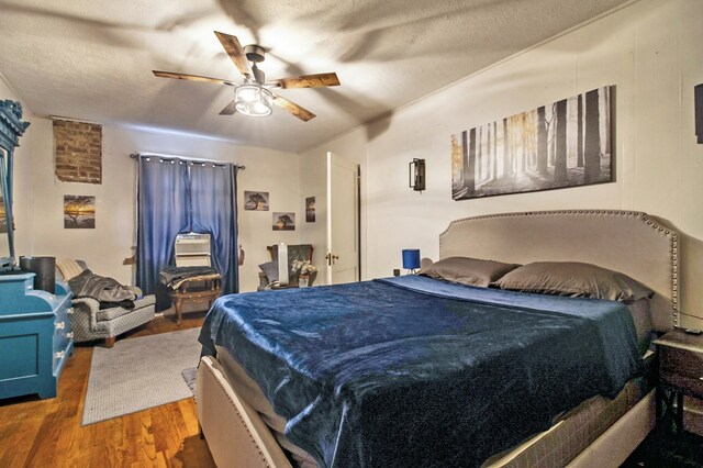 bedroom with a ceiling fan, a textured ceiling, and wood finished floors