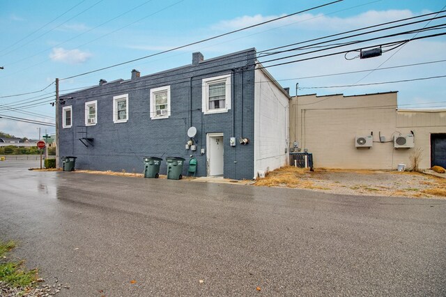 view of property exterior with central AC and brick siding