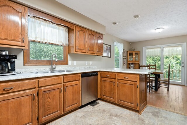 2876 Hilham Hwy, Hilham, TN 38568 - kitchen featuring stainless steel dishwasher, brown cabinets, a peninsula, light countertops, and a textured ceiling