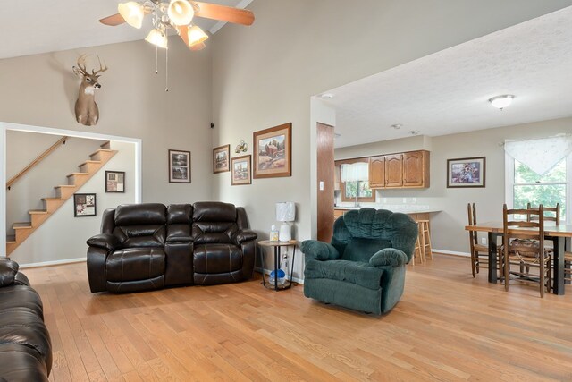 2876 Hilham Hwy, Hilham, TN 38568 - living room with light wood-style flooring, ceiling fan, stairs, and a towering ceiling