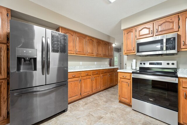 2876 Hilham Hwy, Hilham, TN 38568 - kitchen featuring appliances with stainless steel finishes, light countertops, and brown cabinets