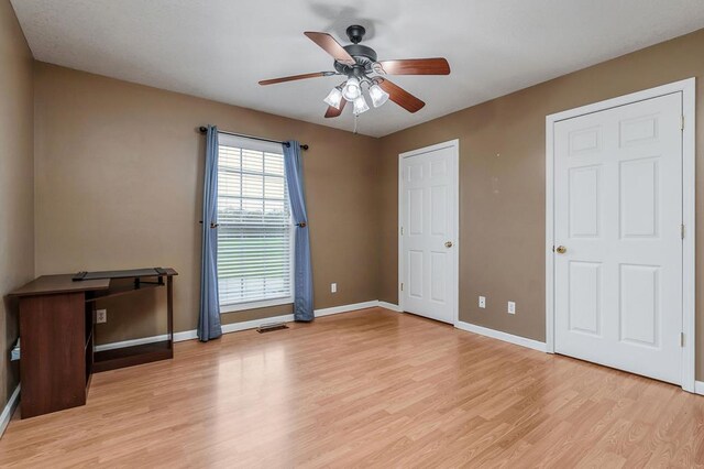 bedroom with baseboards, visible vents, ceiling fan, and light wood finished floors