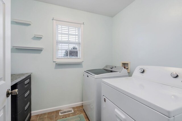 washroom with washer and clothes dryer, visible vents, laundry area, baseboards, and tile patterned floors