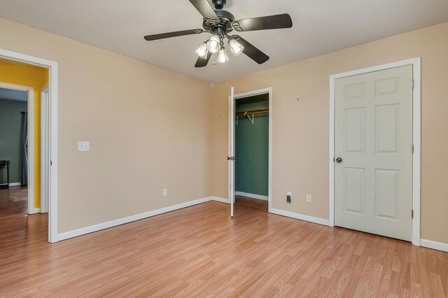 unfurnished bedroom with ceiling fan, light wood finished floors, a closet, and baseboards