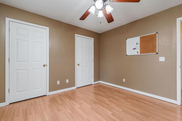 unfurnished bedroom with light wood-style floors, baseboards, and a ceiling fan