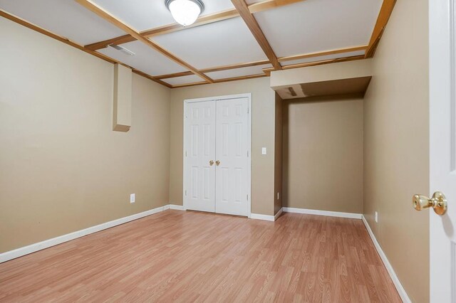 unfurnished bedroom with light wood finished floors, a closet, and baseboards