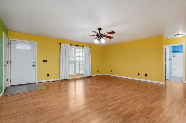 unfurnished living room featuring light wood-style floors, ceiling fan, and baseboards