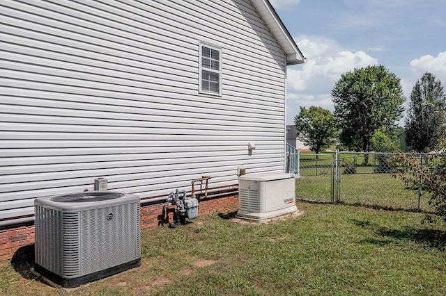 view of side of property with fence, cooling unit, and a yard