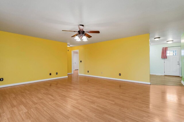 unfurnished room with light wood-type flooring, ceiling fan, and baseboards