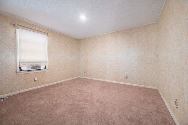 empty room with wallpapered walls, a textured ceiling, and carpet flooring