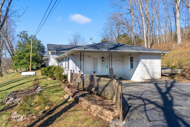 view of front of property with a porch, a front yard, and brick siding