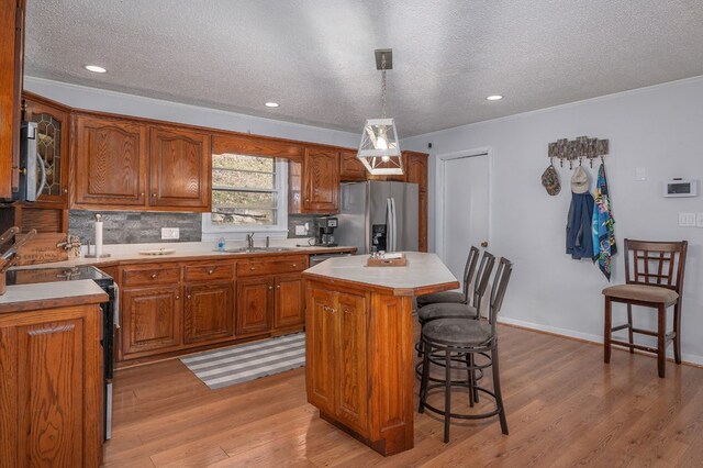 kitchen featuring a kitchen bar, stainless steel appliances, light countertops, and a center island