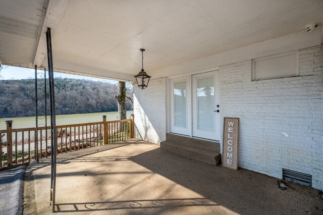 view of patio featuring a water view and a wooded view