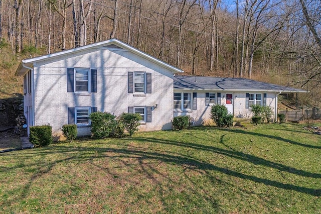 split level home featuring brick siding and a front yard