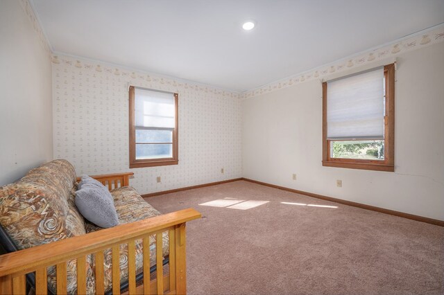 interior space featuring wallpapered walls, ornamental molding, carpet, and baseboards