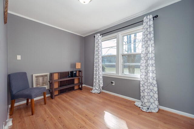 living area with ornamental molding, baseboards, and light wood finished floors