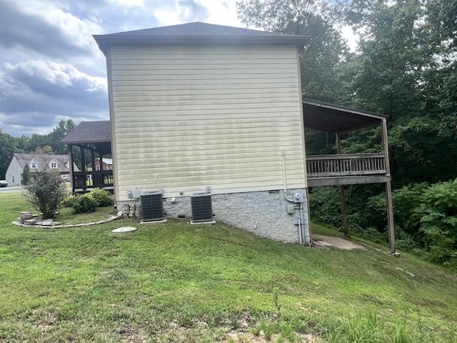 view of property exterior with crawl space, central AC unit, and a lawn