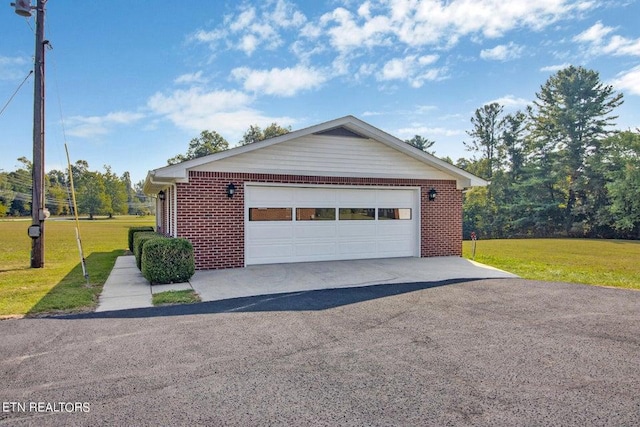 view of front of property with a garage, a front yard, and brick siding