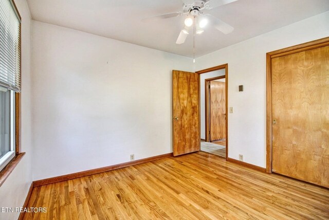 unfurnished bedroom with light wood finished floors, a ceiling fan, baseboards, and a closet