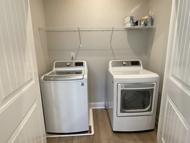 laundry room featuring laundry area, separate washer and dryer, and wood finished floors