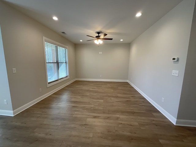 empty room with recessed lighting, visible vents, a ceiling fan, wood finished floors, and baseboards