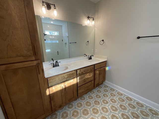 full bathroom featuring double vanity, a stall shower, baseboards, and a sink