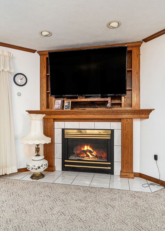 details with a textured ceiling, ornamental molding, a tiled fireplace, and baseboards