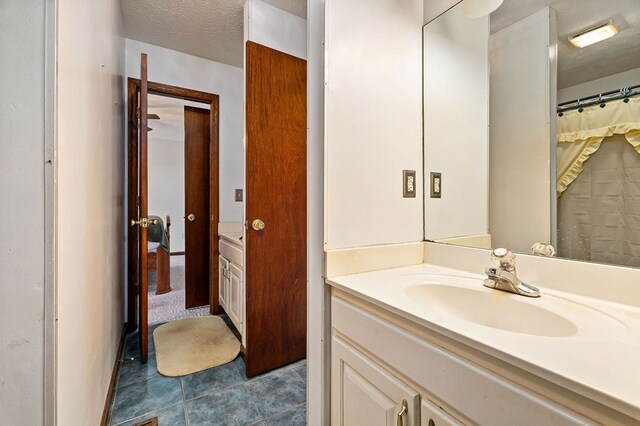 bathroom featuring tile patterned flooring, a textured ceiling, and vanity